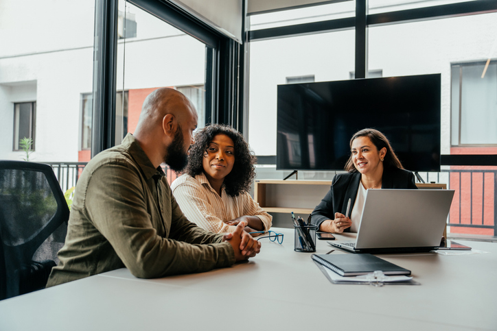 Couple talking to real estate agent in office